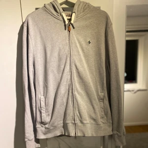 Grå zip från Morris - Tja, säljer nu min gråa zip hoodie från Morris. De är storlek XL på tröjan men den sitter som en L. Tröjan har använts men är i fint skick utan defekter. Säljer den för att den är lite för kort för mig. Hör av dig vid frågor eller vid fler bilder👍😃