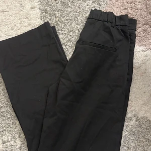 Svarta kostymbyxor - Snygga svarta kostymbyxor med elastisk midja och raka ben. Perfekta för en stilren look.