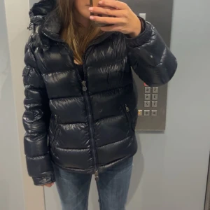 Moncler Maya - Säljer en snygg svart pufferjacka från Moncler i mycket bra skick. Jackan är knappt använd och säljer pågrund av att den är för stor för mig. Förpackningen till jackan följer med. Har tyvärr inte kvar något kvitto. Pris kan diskuteras vill få såld så fort som möjligt!