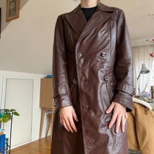 INTRESSEKOLL Brun skinnrock från Malungs Butikerna - Säljer en stilren brun skinnrock från Malungs med dubbelknäppning och klassisk krage. Rocken har skärp i midjan, långa ärmar och en elegant passform som passar perfekt för höst och vår. Svensk design med hög kvalitet. LÄGG GÄRNA BUD!!💓