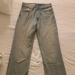 Blå jeans från Zara - Säljer ett par klassiska blå jeans från Zara i storlek EUR 34. De har en dragkedja och knapp framtill. Perfekta för vardagsbruk med en straight passform som ger en tidlös look. Använda cirka 3 gånger men inga defekter såsom fläckar eller annat slitage. Säljar pga fel storlek, skriv mer än gärna ifall du vill ha fler bilder!