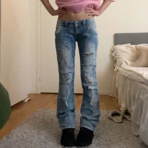 Low waist bootcut jeans  - Såå snygga lågmidjade ljusblå utsvängda jeans med hål och coola detaljer i mycket bra skick!! Midja: 38 Innerben: 81 Ytterben: 100 Gren: 19 Lår: 23,5 centimer❣️