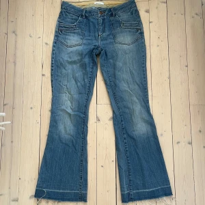 Utsvängda blå jeans  - Säljer ett par snygga blå jeans från Promod. De har en bootcut-stil och är i bra skick. Midjemått: 40cm Innerbenslängd: 73cm