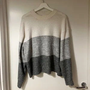 Randig tröja från H&M - Säljer en mysig randig tröja från H&M i beige och grå toner. 