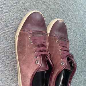 Vin röda lanvins - Säljer ett par vin sneakers i mocka med snörning. De har en vit sula och är i bra skick med några tecken på användning ganska slitna men fins mer att ge