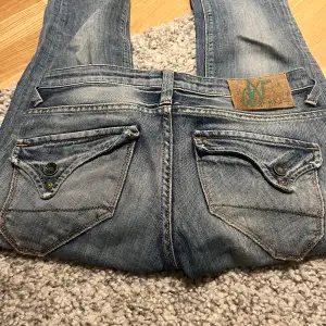 Säljer ett par snygga blå jeans från X-Shape. Detaljerade bakfickor med knappar. Oklar storlek 