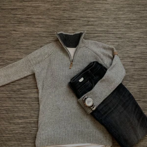 Grå stickad swedemount tröja - Säljer en snygg grå stickad tröja från swedemount med dragkedja i halsen. Perfekt för kyliga dagar och afterski, den har långa ärmar och en bekväm passform. Tröjan är i mycket bra skick och passar både till vardags och lite finare tillfällen.