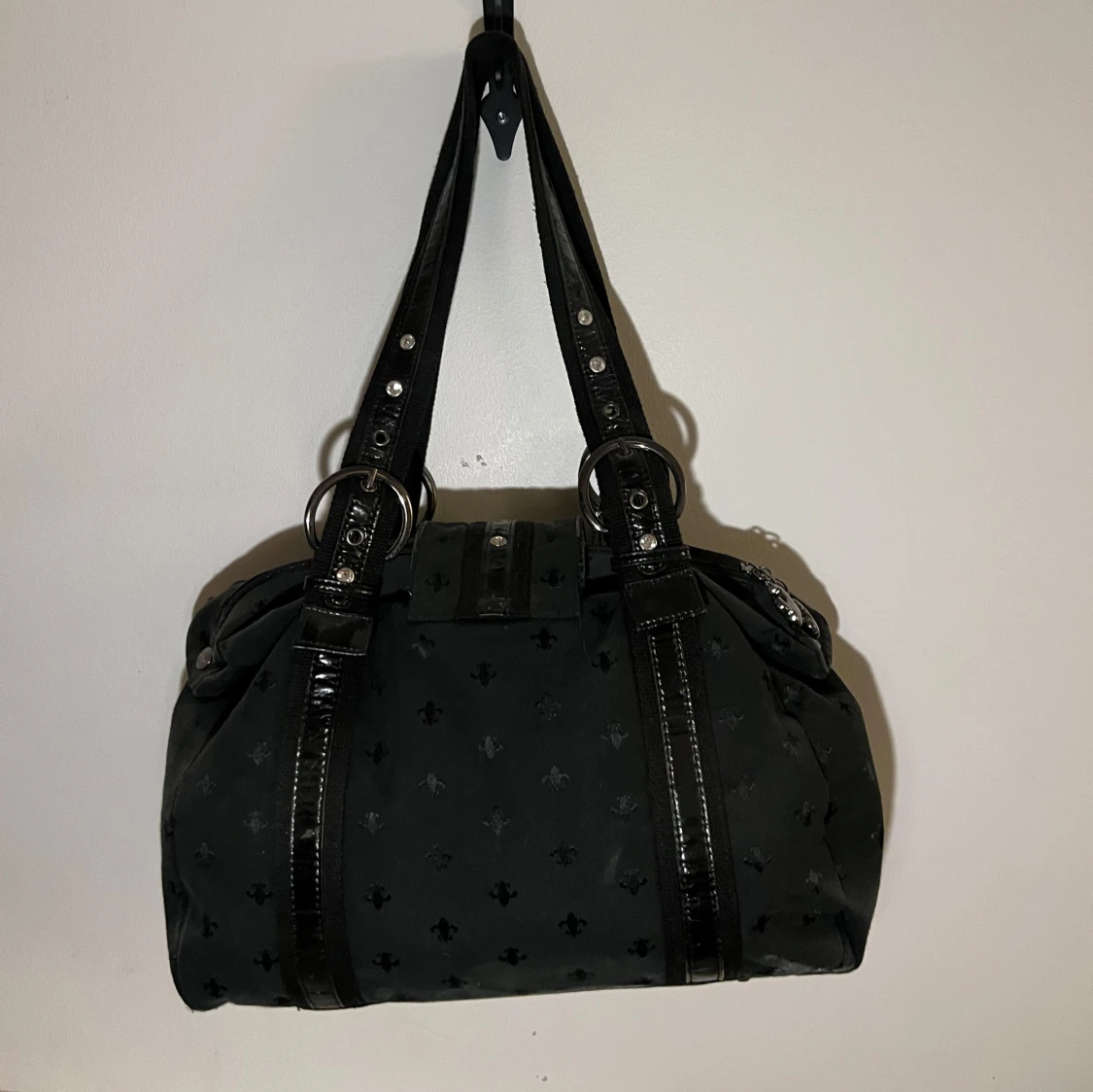 Svart axelväska med dekorativt emblem - 90