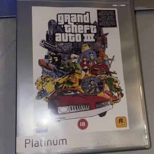 Grand Theft Auto III Platinum - Säljer Grand Theft Auto III i Platinum-version för PlayStation 2. Spelet utspelar sig i Liberty City och erbjuder en öppen värld med massor av action och äventyr. Omslaget har en ikonisk design med karaktärer och fordon. Perfekt för samlare eller nostalgiker!