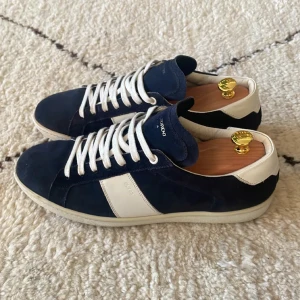 Saint Laurent - Säljer ett par snygga sneakers från Saint Laurent i blått och vitt. De är i mycket bra skick och kommer med originalförpackning. Skorna har en klassisk snörning och är gjorda i skinn och mocka.