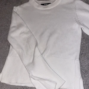 Vit stickad tröja från Bik Bok - Säljer en superfin vit stickad tröja från Bik Bok. Den har en klassisk design med långa ärmar och ribbade detaljer vid ärmslut och nederkant. Perfekt för både vardag och lite kyligare dagar. Passar till allt och är i mycket bra skick!
