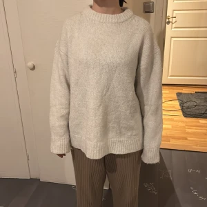 Vit stickad tröja från Zara - Säljer en mysig vit stickad tröja från Zara. Tröjan har en klassisk rund hals och långa ärmar, perfekt för kyligare dagar. Den är enkel och stilren, vilket gör den lätt att matcha med olika outfits.