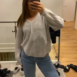 Säljer en mysig vit stickad tröja med v-ringning. Tröjan har långa ärmar och en perfekt passform, perfekt för kyligare dagar. Passar bra till jeans eller kjol för en stilren look.