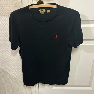 Svart t-shirt från Ralph Lauren. Storlek S. - Säljer en svart t-shirt från Ralph Lauren i custom slim fit. Skön t-shirt. Börjar bli förliten för mig dedär säljer jag. Inga slitningar eller någonting som nyskick.