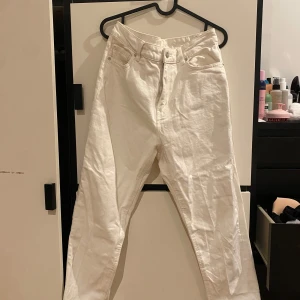Vita jeansbyxor - Säljer ett par vita momjeans i bra skick. De är högmidjade och perfekta för både vardag och festliga tillfällen. Passar till allt och är superbekväma. Skrynklig eftersom den länge legat i garderoben men med lite strykning sitter de som en smäck!