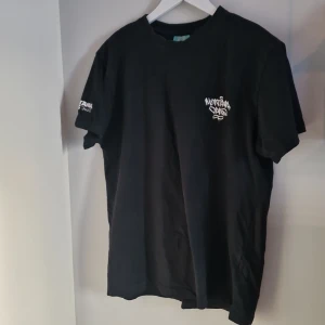 Svart t-shirt från Montana Cans - Säljer en svart t-shirt från Montana Cans i storlek M. Den har ett coolt tryck med märkesloggan både fram och bak. Perfekt för streetwear-stilen och gjord i mjukt bomullsmaterial. Kortärmad och i mycket bra skick. Passar perfekt till vardags eller för en avslappnad look.