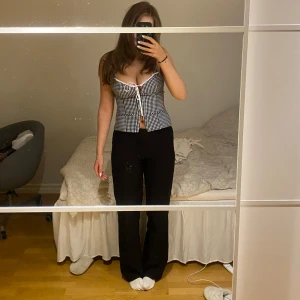 Svartvit rutig topp med knappar - Säljer en superfin svartvit rutig topp med knappar framtill. Den har en tight passform och är ärmlös med breda axelband. Perfekt för sommaren eller en utekväll. Toppen är i mycket bra skick och ger en stilren look. Prislapp kvar aldrig använd.