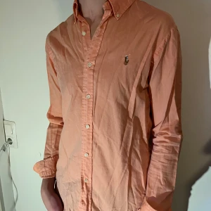 Ralph Lauren skjorta - Snygg Ralph Lauren skjorta i orange/rosa färg. Storlek S. Jag är 1,80 lång och väger 70 kg.
