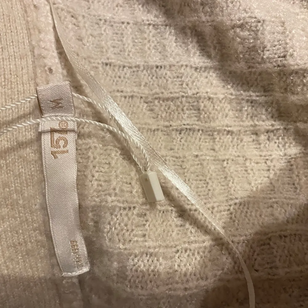 stickad beige tröja med knappar. Neuletakit & Villapaidat.