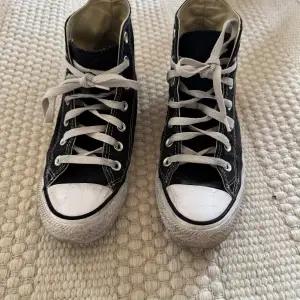 Säljer ett par klassiska svarta höga Converse sneakers i bra skick. Perfekta för vardagsbruk och ger en cool stil till vilken outfit som helst. 