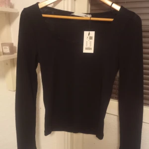 Svart långärmad topp  - Säljer en svart långärmad topp i strl M från lager 157, aldrig använd, köptes för ca 1 månad sen men har tyvärr bara hängt i garderoben! Köptes för 150kr, säljer den för 100kr + frakt! 