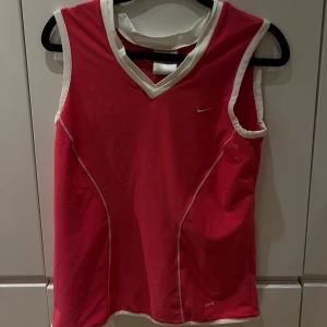  sporttopp från Nike - sporttopp från Nike med vita detaljer och v-ringning. Perfekt för träning, aldrig använd