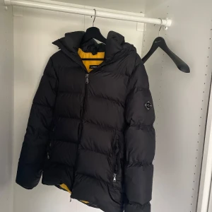 Svart dunjacka från J.Lindeberg - Säljer en svart dunjacka från J.Lindeberg i storlek XS. Det finns en liten reva på ryggen som inte borde vara så svår att fixa, men annars i bra skick. Perfekt för vintern ❄️