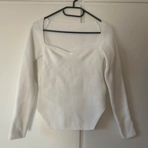 Vit ribbad tröja - Säljer en stilren vit ribbad tröja med lång ärm och fyrkantig halsringning. Perfekt för både vardag och fest. Tröjan har en figurnära passform som framhäver silhuetten. Superbekväm och lätt att matcha med olika outfits! Är i storlek S men passar M
