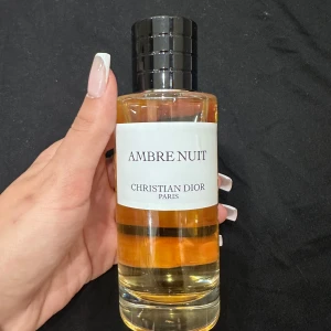 Ambre Nuit parfym från Christian Dior - Säljer en lyxig flaska Ambre Nuit från Christian Dior. Parfymen har en elegant och stilren design med en genomskinlig flaska och svart kork. Perfekt för den som älskar exklusiva dofter. Flaskan är nästan full och redo att användas för speciella tillfällen.