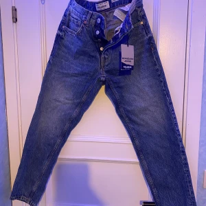 Blå jeans från Pull&Bear - Snygga blå standard jeans från Pull&Bear med klassisk femficksdesign. De har en rak passform och är tillverkade i slitstarkt denim. Perfekta för en avslappnad stil. Och aldrig använda. Säljer för dem va lite fö små. 