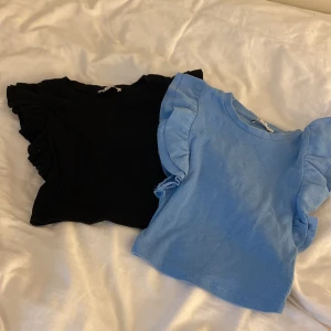 Svart och blå ribbad topp från Zara - Två snygga ribbade toppar från Zara i svart och blått. Båda har volangdetaljer vid ärmarna och en bekväm passform. Perfekta för att ge din outfit en trendig touch. Helt nya!! Säljer för 50kr för båda!❤️ eller 30kr för en❤️ Strl S på båda ❤️