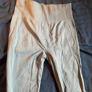 Ljus blå ribbade träningstights - Snygga blå leggings med ribbad hög midja för extra komfort. Perfekta för både träning och avslappning. De har en tight passform som framhäver figuren. Detaljet på baksidan som verkligen framhäver.