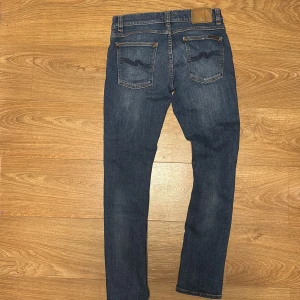 Blå jeans från Nudie Jeans - Snygga blå jeans från Nudie. De är slim fit i modellen tight terry. Jätte fint skick, näst intill nya. Storlek w29 L30