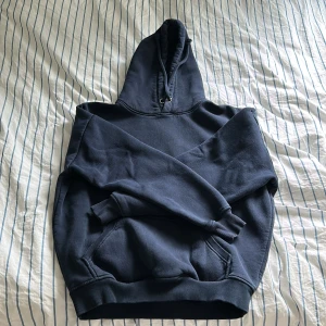 Mörkblå hoodie - Säljer en stilren mörkblå hoodie med klassisk design. Den har en rymlig huva med dragsko och en stor magficka framtill. Perfekt för en avslappnad look 💕🎀
