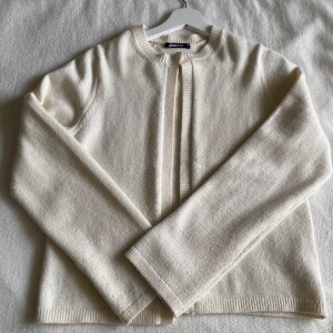 Krämvit kofta från Gina Tricot - Säljer en stilren Beige (creme vit) kofta från Gina Tricot i storlek M. Den har en enkel knapp framtill och är tillverkad i ett mjukt material. Passar perfekt till nästan allt. ❣️