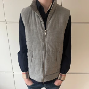 Grå quiltad väst från Dressmann - Snygg grå quiltad väst från Dressmann. Perfekt för lager-på-lager-stil. Västen har en stilren design med praktiska fickor och en bekväm passform. Ny skick-10/10 storlek S, nypris 1099, mitt pris 599