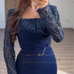 Marinblå klänning från Asyaa Dress - Elegant marinblå klänning med långa ärmar och glittriga detaljer. Perfekt för en festlig kväll. 