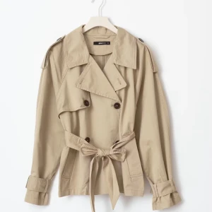 Beige trenchcoat med knytbälte - Snygg beige trenchcoat med knytband i midjan och stora knappar framtill. Jackan har långa ärmar och en klassisk krage. Perfekt för en stilren look. Jackan köptes ifrån ginatricot för 700kr och säljs nu för 400kr. Storlek xss men passar för dig som normalt är xs/s. Fråga gärna om fler bilder vid undringar☺️