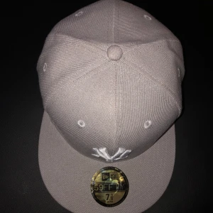 Grå keps från New Era - Snygg grå keps från New Era, modell 59FIFTY. Kepsen har en broderad logga framtill och en MLB-logga baktill. Perfekt för en stilren look.
