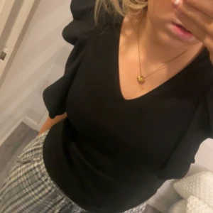 Svart topp med puffärmar - Snygg svart topp med puffärmar och rund halsringning. Perfekt för en stilren look. Passar bra till både jeans och kjol.