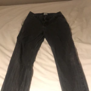 Grå jeansbyxor - Snygga grå jeansbyxor med en klassisk straight passform. De har en diskret tvättad look och är perfekta för en avslappnad stil. Byxorna har fickor både fram och bak samt en traditionell dragkedja och knappstängning märket är grunt