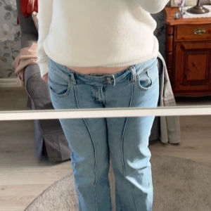 Blå bootcut jeans - Säljer ett par klassiska blå bootcut jeans med låg midja. De har en snygg passform och är perfekta för en avslappnad stil. Jeansen har fickor fram och bak samt en dragkedja med knapp framtill.