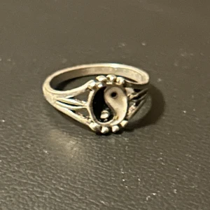Silverfärgad ring med yin-yang-symbol - Säljer en silverfärgad ring med en yin-yang-symbol. 