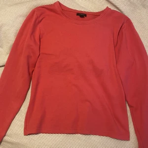 Rosa långärmad tröja från Lindex - Säljer en enkel och stilren rosa långärmad tröja från Lindex. Perfekt för en avslappnad look. Tröjan har en rund halsringning och är gjord i ett mjukt material.