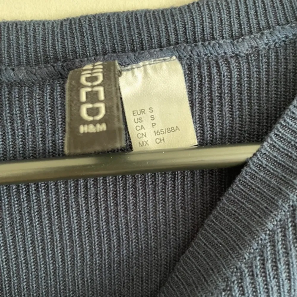 Säljer en snygg blå ribbad tröja från H&M. Tröjan har långa ärmar och en rund halsringning. Perfekt för en stilren look. Passar bra till både jeans och kjol.. Neuletakit & Villapaidat.