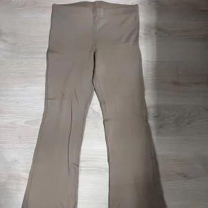 Beige byxor med bootcut - Snygga beige byxor med bootcut-stil. De har en hög midja och är tillverkade i ett mjukt material som ger en bekväm passform.