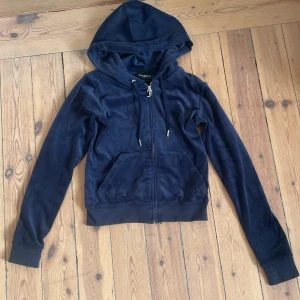 Mörkblå Juicy Couture tröja  - Säljer en snygg mörkblå hoodie från Juicy Couture. Den har en dragkedja framtill och en mysig huva. Perfekt för en avslappnad stil. Har även byxorna till salu! Hör av dig vid intresse! 💙nypris: 1300kr. Pris kan diskuteras!