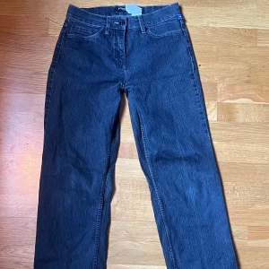 Svarta/mörkgrå jeans från Robell - Snygga svarta/mörkgråa jeans från Robell med en unik broderad detalj på bakfickan. Har blivit handsydda lågmidjade. 
