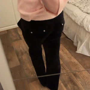 Svarta mjukisbyxor från Juicy Couture - Säljer ett par svarta mjukisbyxor från Juicy Couture. Byxorna har en bekväm passform med dragsko i midjan och fickor framtill. Perfekta för en avslappnad stil. Säljer för att dom aldrig kommit till användning och därav nästan aldrig använda! 