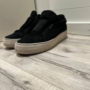 Arigatos 360 laceless  - Snygga svarta sneakers från Axel Arigato med en stilren design. Skorna har en tjock vit sula och är tillverkade i mocka. Perfekta för en avslappnad och trendig look. Väldigt fräscha men var för stora för mig. Kom gärna med prisförslag:) Box ingång såklart 